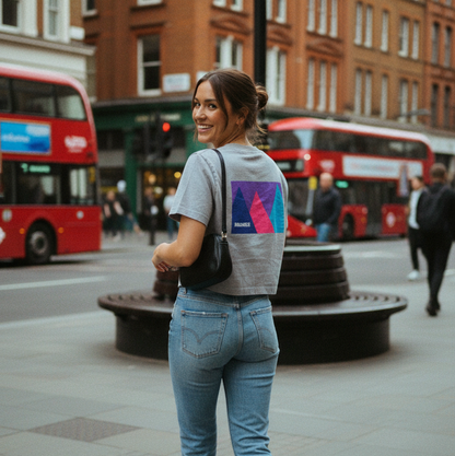 Woman walking on a city street with red double-decker buses in the background